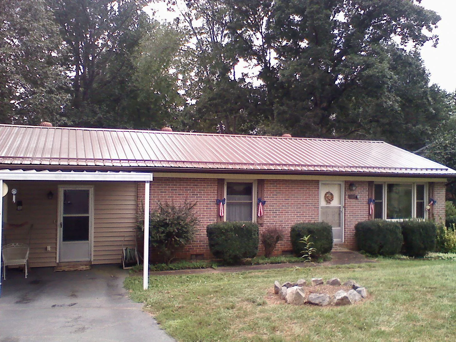 Bronze metal roof and carport on a brick ranch home — Roof Repair work by our crew in Trinity